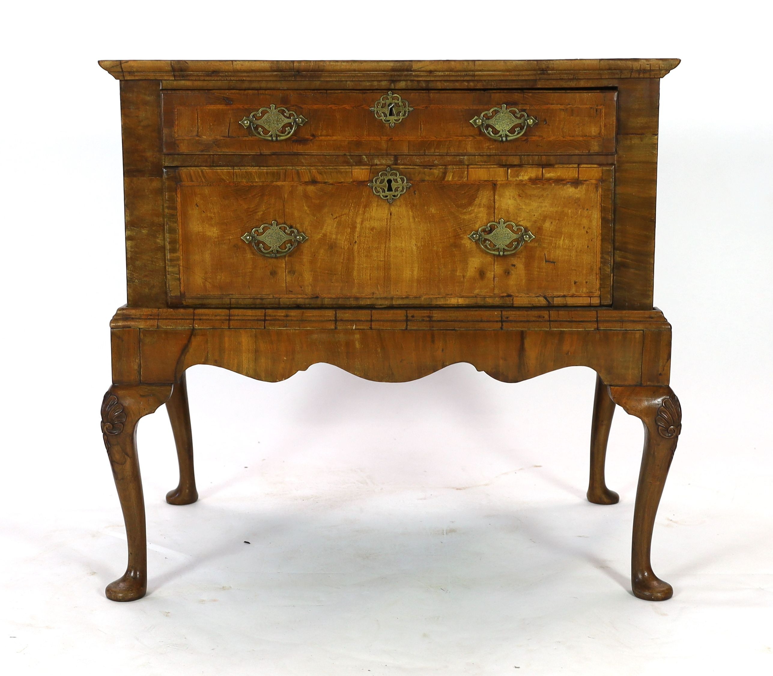 A mid 18th century featherbanded walnut chest on stand, with moulded quarter veneered top, one long and one deep drawer, on stand with shell kneed cabriole legs and pad feet, width 96cm depth 62cm height 93cm
